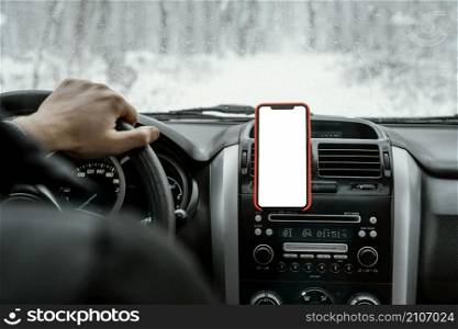 back view man driving car road trip with smartphone