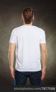Back view man guy in blank shirt with copy space.. Back rear view of fashionable man in white blank shirt with empty copy space. Guy in studio on black. Casual fashion advertisement.