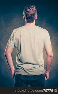 Back view man guy in blank shirt with copy space.. Back rear view of fashionable man in blank shirt with empty copy space. Guy in studio on black. Casual fashion advertisement. Instagram cross filter.