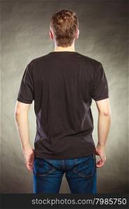 Back view man guy in blank shirt with copy space.. Back rear view of fashionable man in black blank shirt with empty copy space. Guy in studio on black. Casual fashion advertisement.