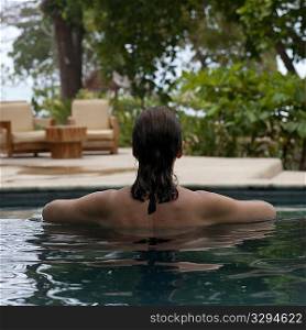 Back view of a brunette woman in a pool in Costa Rica