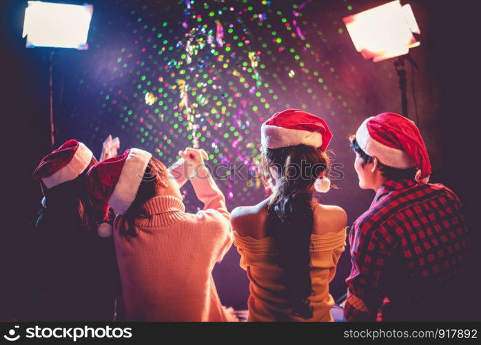 Back view of Asian young peoples who celebrating Christmas and New Year. Holiday and Happiness concept. Friendship and Relax theme.