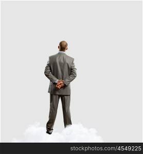 Back view of businessman. Back view image of businessman with arms crossed behind back. Place for text