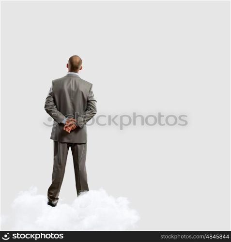 Back view of businessman. Back view image of businessman with arms crossed behind back. Place for text
