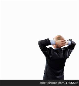Back view of businessman. Back view image of businessman with arms crossed behind head. Place for text