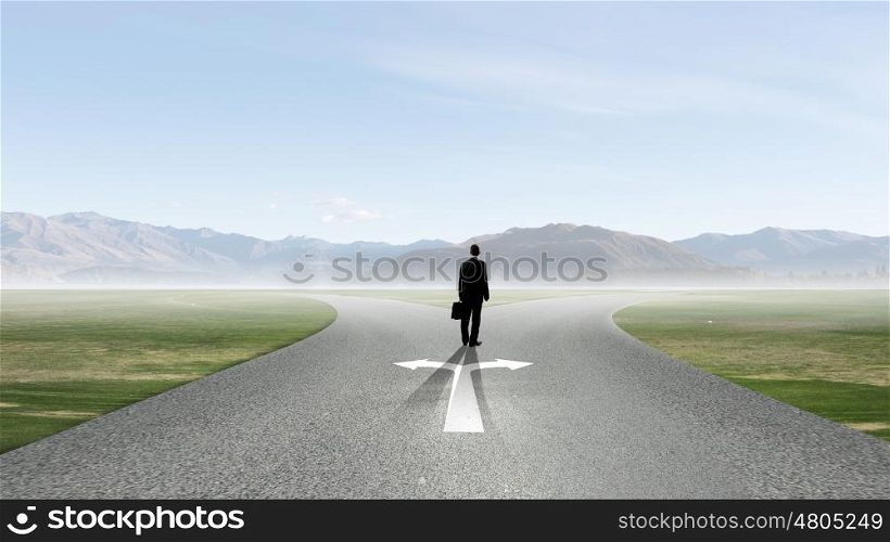 Back view of businessman standing at crossroads and making choice. Choose your way