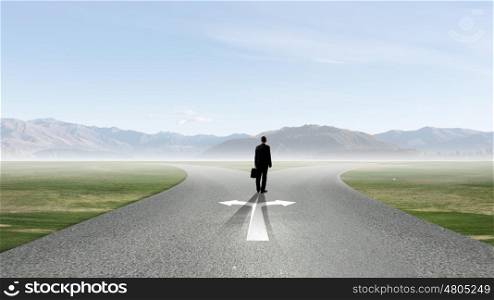 Back view of businessman standing at crossroads and making choice. Choose your way