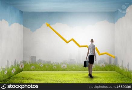 Back view of businesswoman looking at growing graph