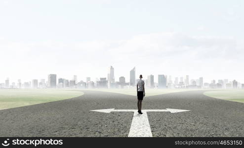 Back view of businesswoman standing on crossroads and making choice. Choose your way