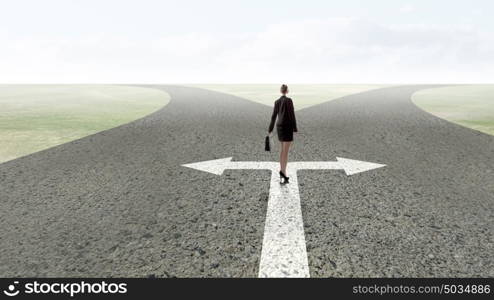 Back view of businesswoman standing on crossroads and making choice. Choose your way