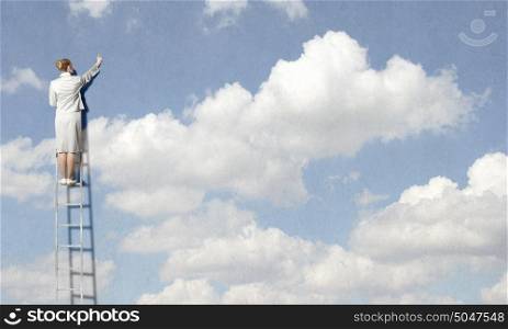 Back view of businesswoman standing on ladder and reaching to cloud. Computing concept