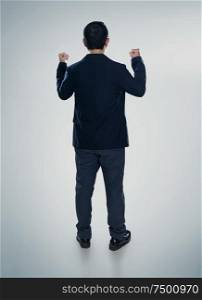 Back view of excited businessman with arms up