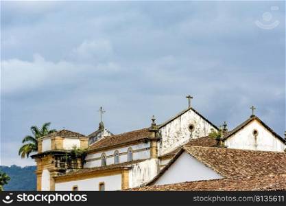 Back view of old colonial style church and roofs in the historic center of Paraty in overcast day. Back view of old colonial style church and roofs