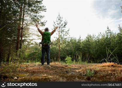 Back view of overjoyed senior man backpacker travel adventure on nature feeling carefree and admiration of environment beauty. Happy overjoyed senior man backpacker enjoying travel adventure on nature