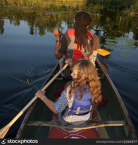 Back view of people rowing a canoe at Lake of the Woods, Ontario