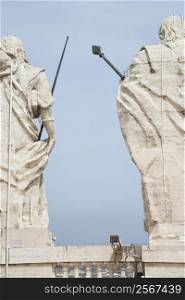 Back view of Roman statues with blue sky in Rome, Italy.