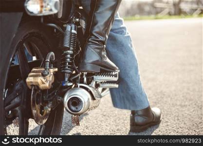 Back view of senior couple legs with boots sitting over motorcycle ready to go. Couple sitting over motorcycle ready to go