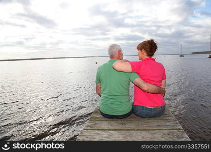 Back view of senior couple sitting on a pontoon