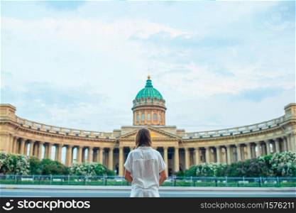Back view of tourist girl looking at Kazan Cathedral in Saint Petersburg. One of most famous churches and museums of Russia. Beautiful architecture of Petersburg.. One of most famous churches amd museums of Russia Kazan Cathedral