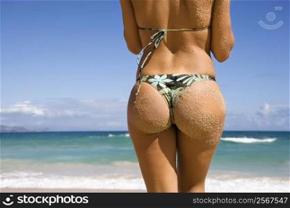 Back view of woman in thong bikini on Maui, Hawaii beach.