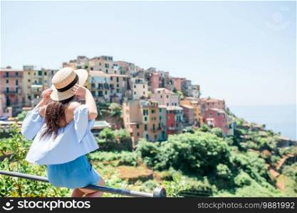Back view of woman looking at scenic view of Cinque Terre, Liguria, Italy. Tourist looking at scenic view of Manarola, Cinque Terre, Liguria, Italy