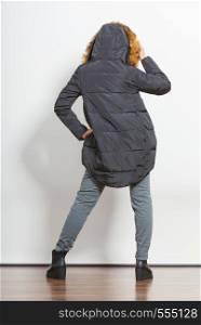 Back view of young fashionable girl wearing jacket with hood. Fashion in winter time. Standing in stride.. Fashion girl in jacket.