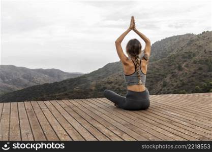 back view woman doing yoga outdoors with copy space