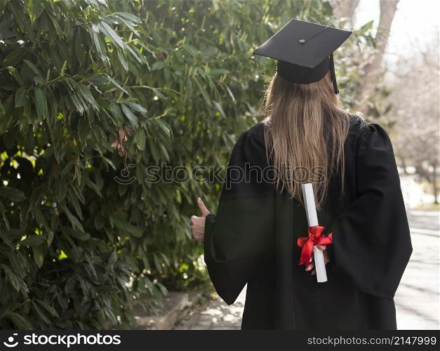 back view woman holding her diploma