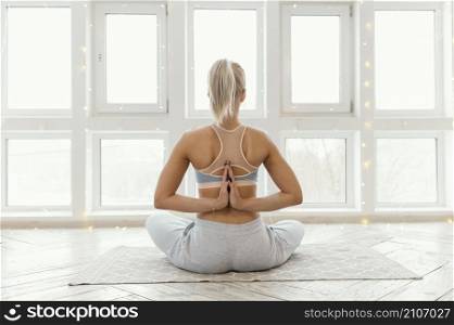 back view woman mat meditating