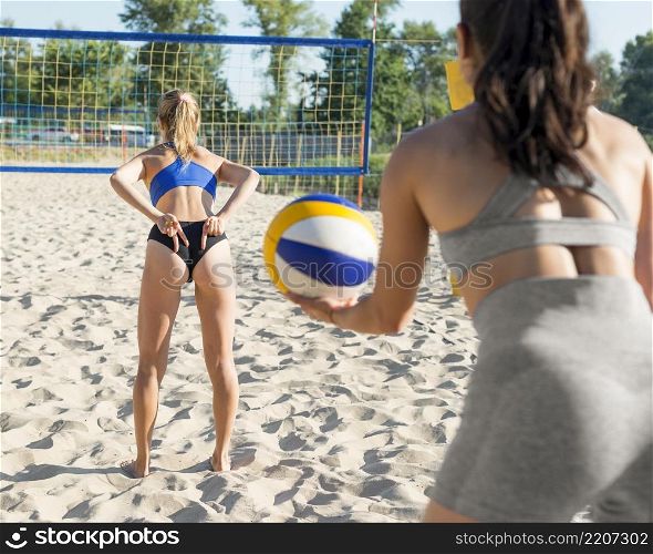 back view woman playing volleyball doing hand signal teammate
