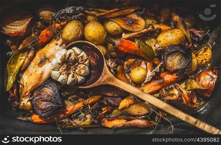 Backed and roasted vegetables , with rabbit meat and cooking spoon, top view