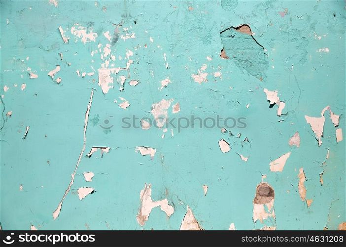 background and texture concept - blue or turquoise wall with peeling paint surface. blue or turquoise wall with peeling paint surface