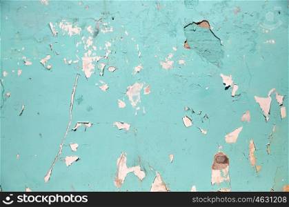 background and texture concept - blue or turquoise wall with peeling paint surface. blue or turquoise wall with peeling paint surface