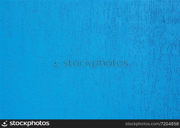 Background and texture of a bright blue wall with cracks.
