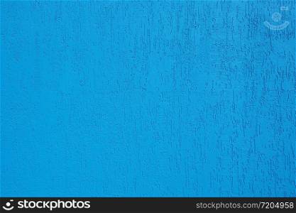 Background and texture of a bright blue wall with cracks.