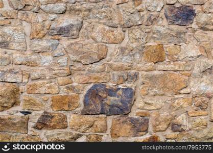 background and texture of old stone wall built with irregular sandstone blocks
