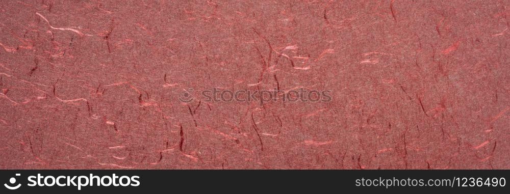 background and texture of red handmade Indian paper created from recycled cotton fabric with silk fibers, panorama banner