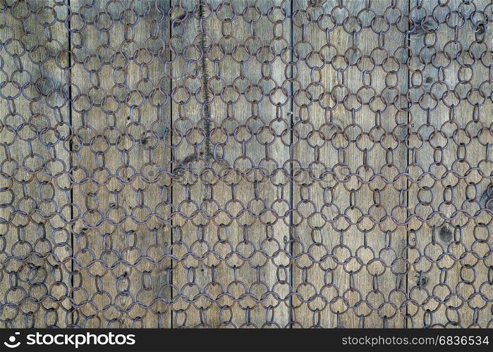 background and texture of vintage chain mesh against weathered wood