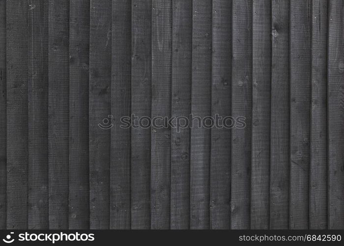 background black stained wooden planks on fencing or barn