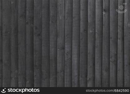 background black stained wooden planks on fencing or barn