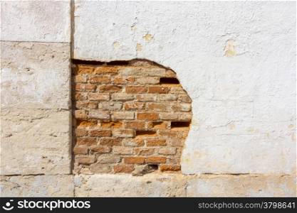 background broken white wall with red bricks