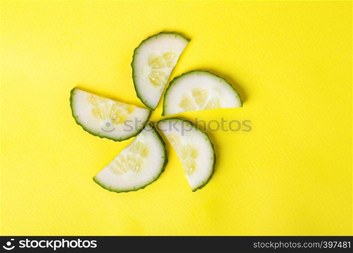 background - cheerful vegetables. flower from cucumbers on a yellow background.