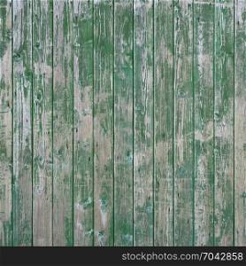 background consisting of square part of green fence of vertical planks with peeling paint