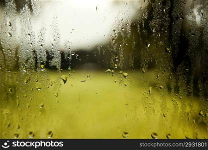 background consisting of wet windshield with rain drops and green white background