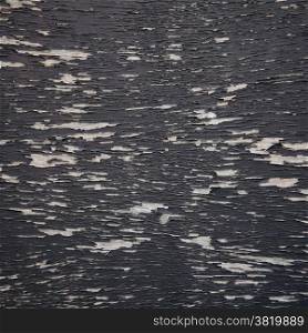 background consisting of wood with pattern of black peeling paint