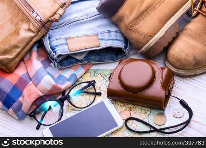 background for a trip - map, glasses, camera, smartphone, shoes, bag, jeans, shirt, coins