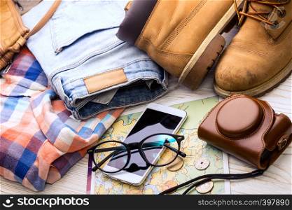 background for a trip - map, glasses, camera, smartphone, shoes, bag, jeans, shirt, coins