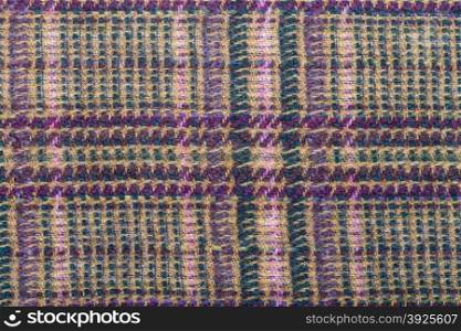 background from checkered green, brown, violet, pink woolen fabric close up