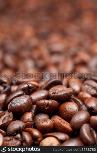background from dark roasted coffee beans with focus foreground