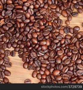 background from roasted coffee beans close up on wooden board